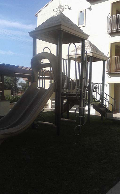 a playground with a slide in front of a building